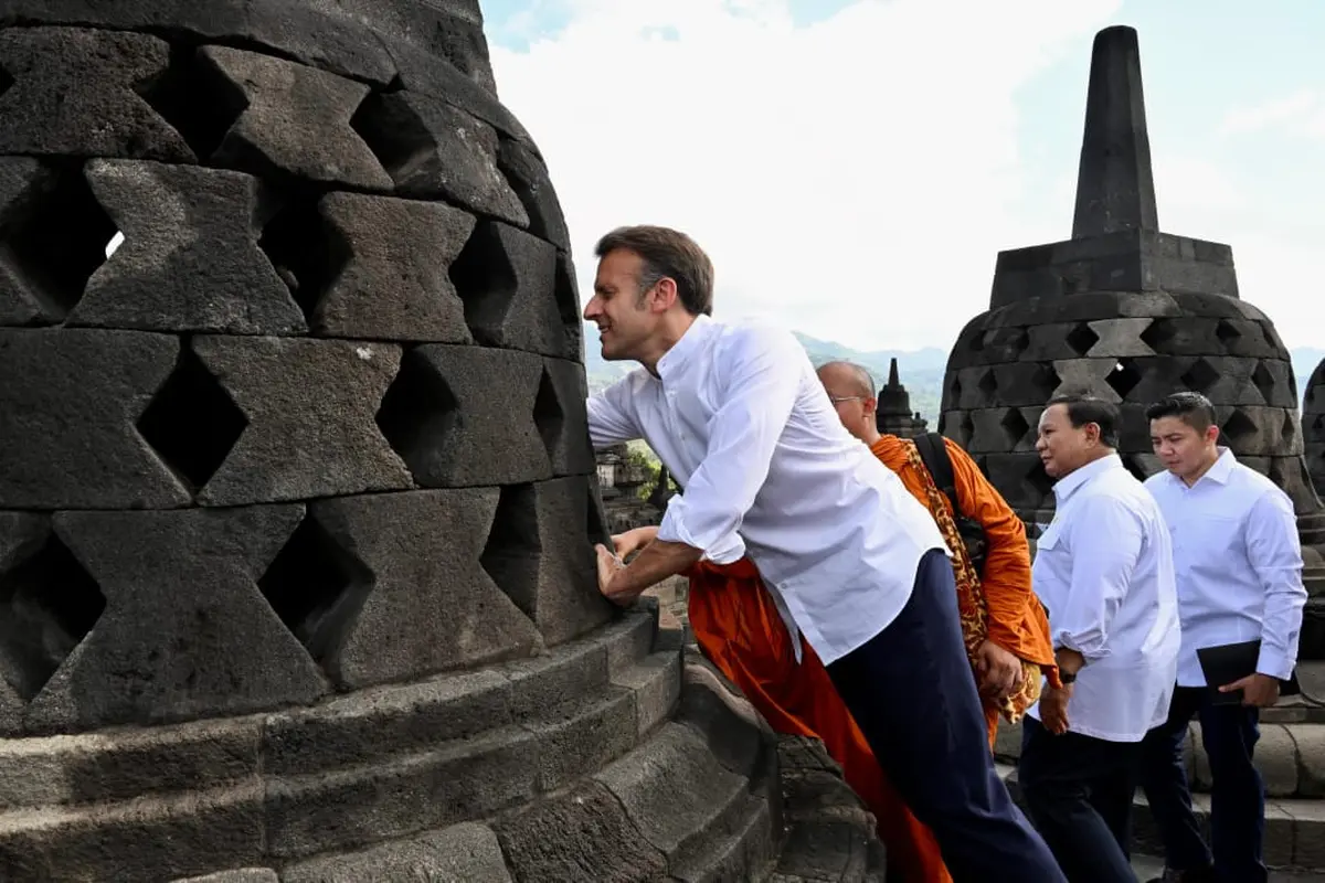 Presiden Macron dan istrinya juga berusaha menggapai patung Buddha yang ada di dalam salah satu stupa di Candi Borobudur.