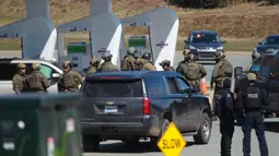Petugas Polisi Mounted Royal Kanada saat menangkap tersangka di sebuah pom bensin di Enfield, Nova Scotia, Minggu (19/4/2020). Seorang pria bersenjata menewaskan lebih dari 10 orang dalam aksinya, termasuk seorang polisi wanita. (Tim Krochak/The Canadian Press via AP)