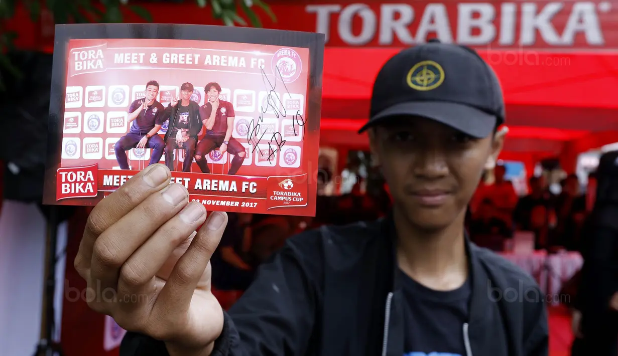 Mahasiswa menunjukan foto bersama dengan dua pemain Arema FC, Ahmad Bustomi dan Beny Wahyudi saat acara Meet and Greet di Stadion Cakrawala, Malang, Kamis (23/11/2017). (Bola.com/M Iqbal Ichsan)
