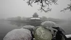 Pengunjung berkerumun untuk mengambil foto di tempat yang indah untuk Kota Terlarang saat salju turun di Beijing, China (18/3/2022). Gelombang dingin melanda banyak bagian China, menyebabkan suhu turun dan mengganggu lalu lintas di daerah yang terkena dampak. (AP Photo/Ng Han Guan)