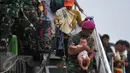 Seorang anggota TNI AD menggendong bayi dari salah satu keluarga eks Gerakan Fajar Nusantara (Gafatar) turun dari KRI Teluk Bone 551 menuju bus jemputan di Dermaga JITC 2 Pelabuhan Tanjung Priok, Jakarta, Kamis (28/1/2016). (Liputan6.com/Gempur M Surya)