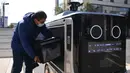 Seorang staf meletakkan makanan ke dalam robot pengiriman di Changsha, Provinsi Hunan, China tengah, pada 14 Februari 2020. Dua robot pengiriman dialihfungsikan untuk mengantar makan siang dan makan malam bagi para karyawan di perusahaan yang melanjutkan produksi di kawasan itu. (Xinhua/Xue Yuge)