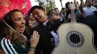 Suporter Meksiko memainkan gitar saat merayakan kemenangan timnya atas Jerman pada Piala Dunia 2018 di Luzhniki Stadium, Moskow, (17/6/2018). Meksiko menan 1-0. (AP/Alexander Zemlianichenko)