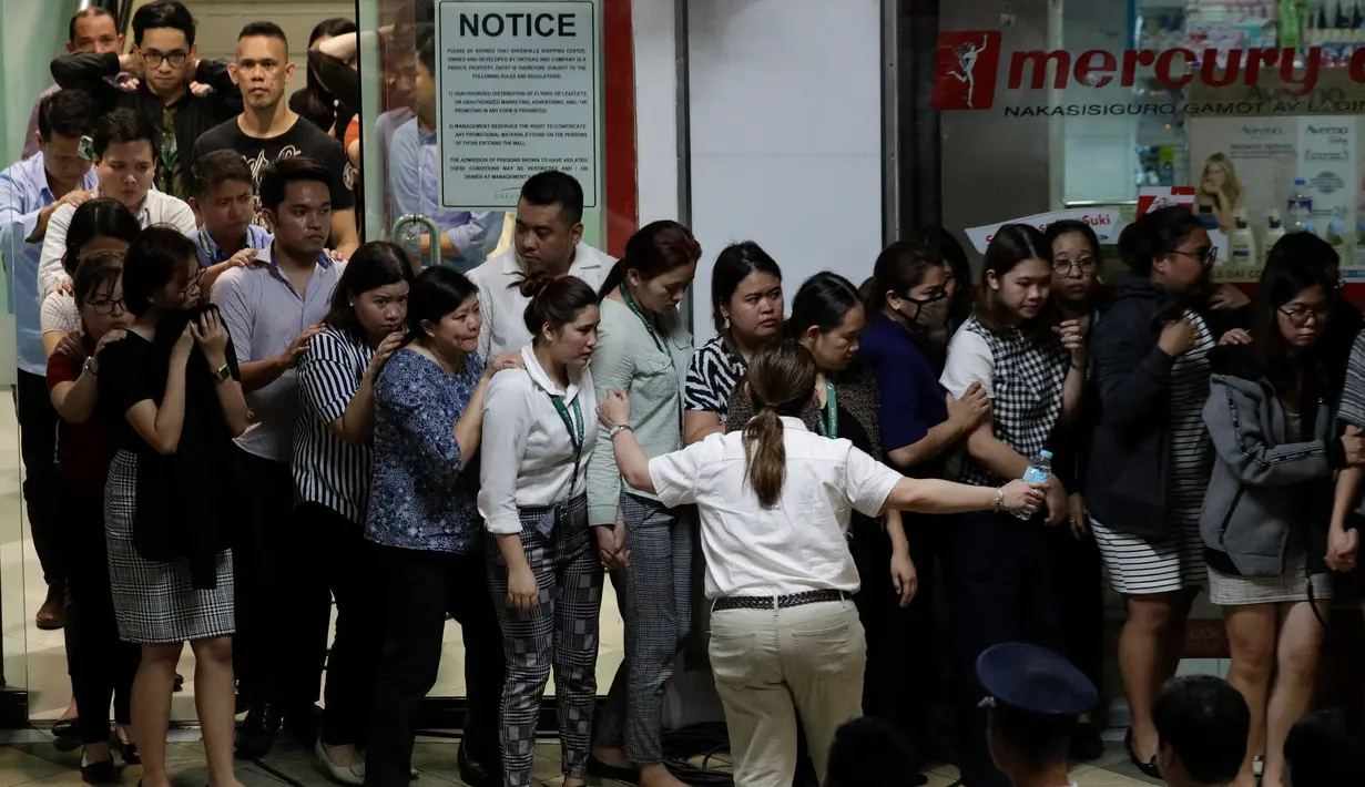 Para sandera berjalan keluar saat dibebaskan dalam penyanderaan di V-Mall, Manila, Filipina, Senin (2/3/2020). Pelaku penyenderaan Alchie Paray menyerahkan diri setelah membebaskan 30 sandera. (AP Photo/Aaron Favila)