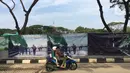 Pengendara sepeda motor melintas dekat pambangunan proyek revitalisasi Taman Monumen Nasional (Monas) di Jakarta, Sabtu (18/1/2020). Sejumlah fasilitas publik akan dibangun di Taman Monas, mulai dari lokasi upacara dan parade. (Liputan6.com/Immanuel Antonius)