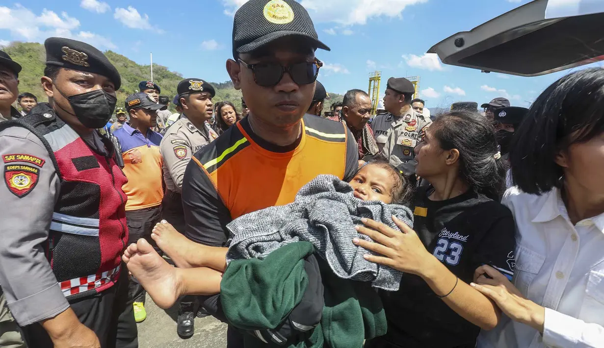 Petugas SAR membawa seorang anak  turun dari kapal pencarian dan penyelamatan di Pelabuhan Lembar, Lombok Barat, Rabu, 12 Agustus 2026. (AFP)