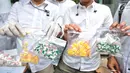 Petugas memperlihatkan barang bukti obat keras saat merilis kasus obat keras yang tidak memiliki izin edar di Mapolda Metro Jaya, Jakarta, Selasa (19/9). Polda Metro menyita 15.367 pil obat keras yang tidak memiliki izin edar. (Liputan6.com/Faizal Fanani)