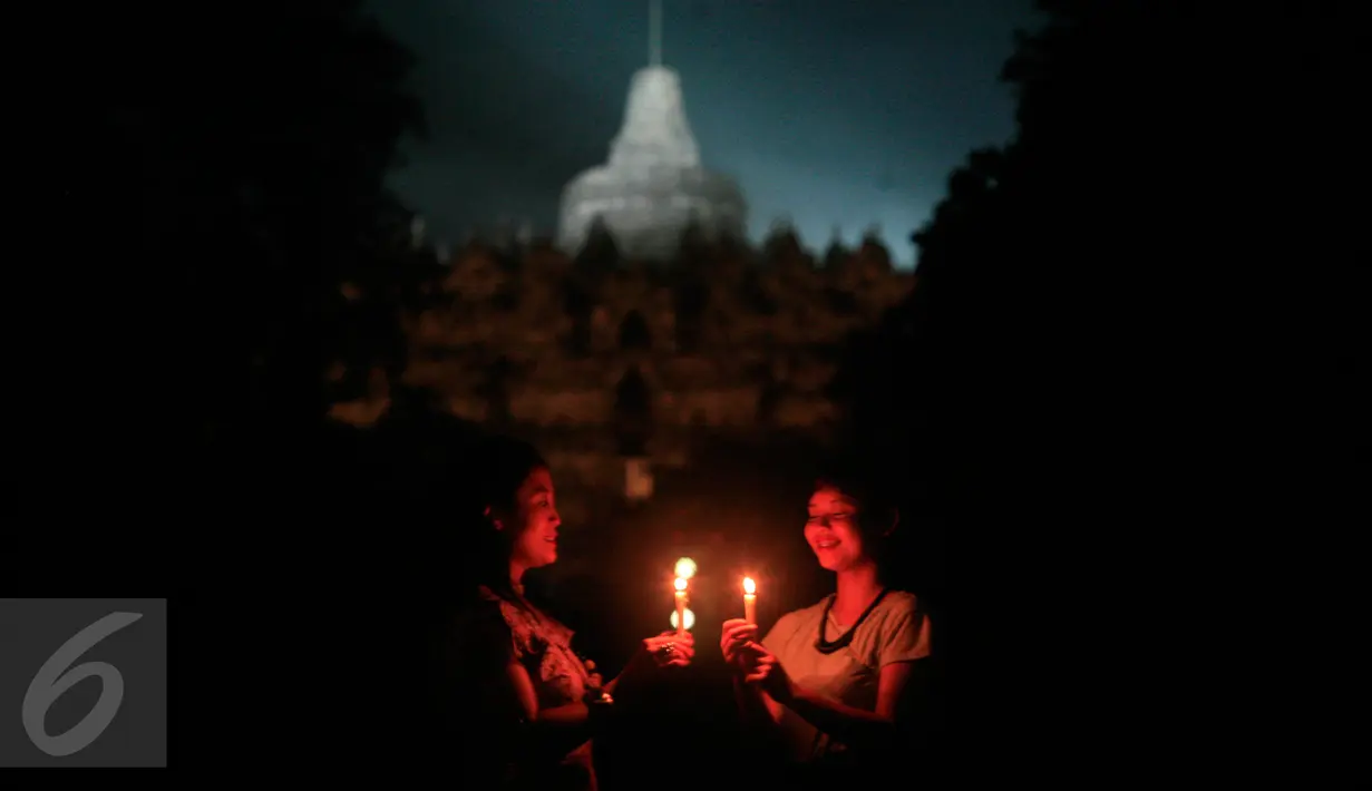 Wisatawan menyalakan lilin saat dilaksanakan program Earth Hour atau peringatan Hari Bumi oleh WWF (World Wildlife Fund for Nature), UNESCO dan Balai Konservasi Borobudur di Candi Borobudur, Magelang, Jawa Tengah, Sabtu (19/3) malam. (Foto: Boy Harjanto)