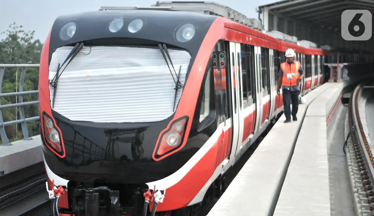 Pekerja melintas di samping rangkaian kereta LRT Jabodebek di Stasiun Harjamukti, Depok, Jawa Barat (13/10/2019). Interior kereta LRT juga dilengkapi dengan kursi prioritas dan khusus disabilitas serta sistem keamanan di dekat pintu keluar. (merdeka.com/Iqbal S. Nugroho)