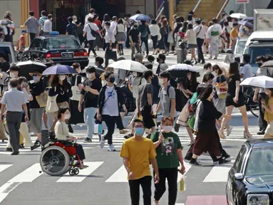 Orang-orang yang memakai masker untuk membantu melindungi diri dari penyebaran virus corona berjalan melintasi persimpangan di Tokyo, Senin (30/8/2021). Jepang masih memerangi lonjakan kasus COVID-19. (AP Photo/Koji Sasahara)