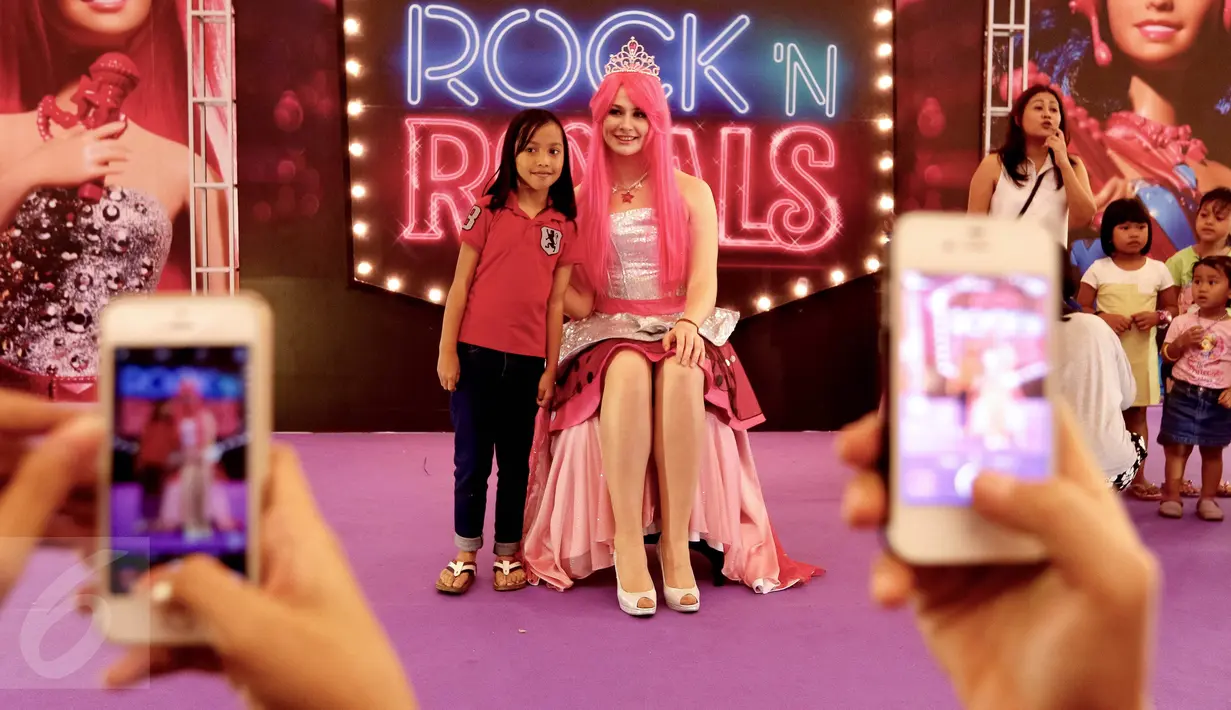 Seorang anak foto bersama wanita cantik berkarakter Barbie di pusat perbelanjaan Lippo Mall Kemang, Jakarta, Sabtu (19/12). Momentum bersama Barbie yang mengangkat tema Barbie Rock N Royals menghadirkan kegiatan menarik.  (Liputan6.com/Fery Pradolo)