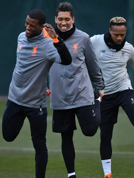 Pemain Liverpool, Georginio Wijnaldum, Roberto Firmino, Nathaniel Clyne melakukan pemanasan saat latihan di Melwood Training Ground, Liverpool, (5/3). Liverpool akan melawan Porto pada leg kedua babak 16 besar Liga Champions. (AFP Photo/Anthony Devlin)