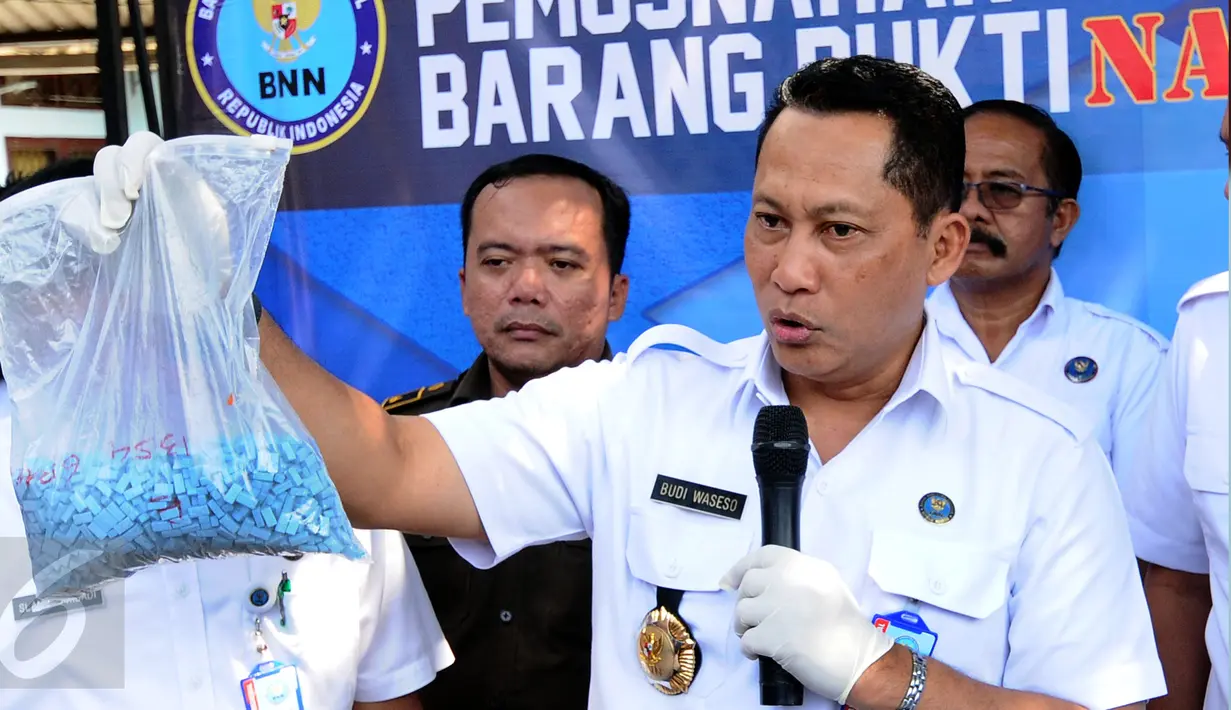 Kepala BNN, Budi Waseso menunjukkan barang bukti pil ekstasi jelang dimusnahkan di halaman kantor BNN, Jakarta, Kamis (9/3). Narkotika yang dimusnahkan jenis sabu 40,57 kilogram dan 44.3787 butir pil ekstasi. (Liputan6.com/Helmi Fithriansyah)