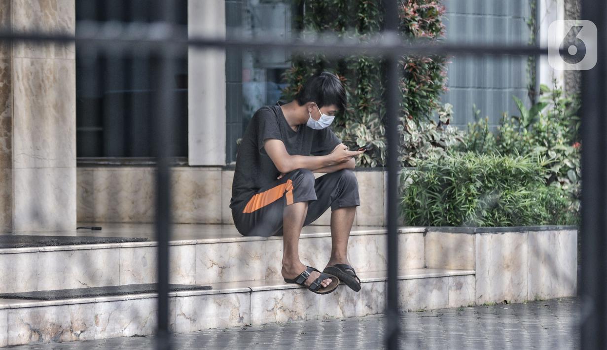 Seorang pasien positif Covid-19 melihat ponselnya saat menjalani isolasi mandiri di sebuah hotel kawasan Salemba, Jakarta, Senin (22/2/2021). Hotel masih menjadi pilihan warga di Jakarta sebagai tempat isolasi mandiri ketika terpapar virus Covid-19. (merdeka.com/Iqbal S. Nugroho)