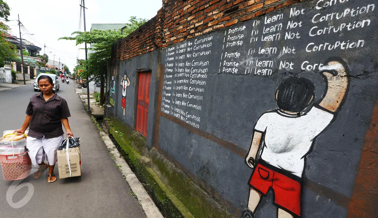 Seorang wanita melintas di depan mural anti korupsi bertuliskan 'I promise i'll learn not corruption' di Jakarta, Minggu (05/03). Mural tersebut mengedukasi masyarakat untuk belajar tidak melakukan praktik korupsi. (Liputan6.com/Helmi Afandi)