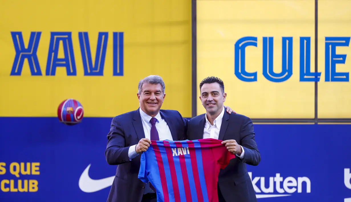 Pelatih baru FC Barcelona Xavi Hernandez (kanan) berpose di samping presiden Joan Laporta selama presentasi resminya di stadion Camp Nou di Barcelona, Spanyol, Senin (8/11/2021). (AP Photo/Joan Monfort)