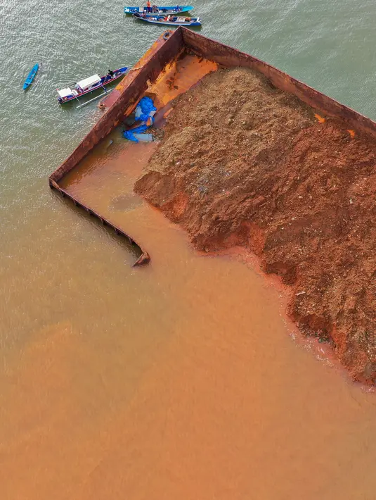 Pantauan udara kondisi kapal dalam posisi miring dengan muatannya yang tumpah mencemari perairan Pantai Gong di Kabupaten Konawe, Sulawesi Tenggara (14/7/2021). (AFP/Ono)