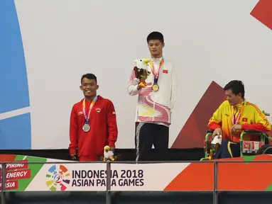 Atlet Indonesia Aris Wibawa saat penyerahan mendali dalam babak final putra 100 meter gaya dada SB7 para renang Asian Para Games 2018 di Aquatic Center, GBK, Jakarta, Senin (8/10). Aris berhasil meraih perak dalam kelas tersebut. (Merdeka.com/Imam Buhori)