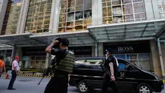Anggota kepolisian melintasi area hotel yang berasap di kompleks Resorts World Manila, Filipina, Jumat (2/6). Seorang pria bersenjata melakukan serangan dengan menembaki ke arah pengunjung dan meja kasino yang ada di dalam hotel. (AP Photo/Aaron Favila)