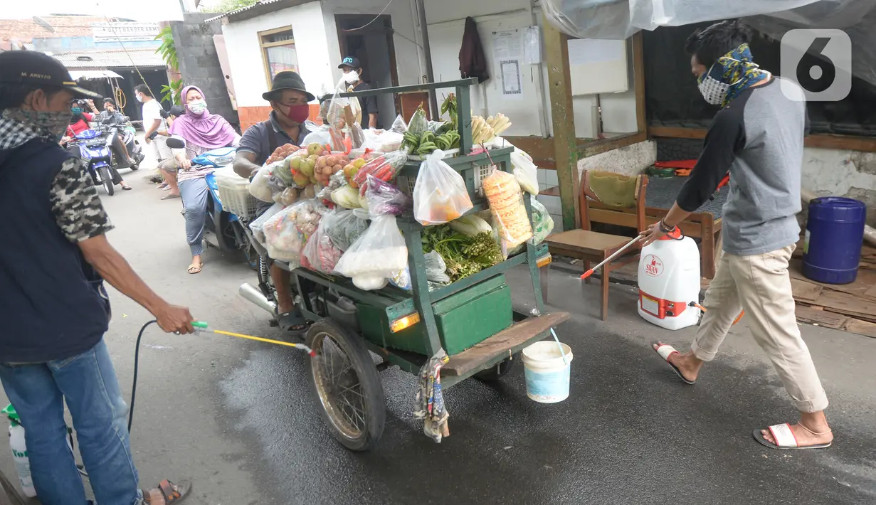 Sejumlah pemuda menyemprotkan cairan disinfektan kepada orang yang akan memasuki RW 10 di kawasan Tanah Kusir, Kelurahan Kebayoran Lama Selatan, Jakarta, Rabu (8/4/2020). Warga menerapkan akses satu pintu masuk pemukiman tersebut untuk mencegah penyebaran corona COVID-19. (merdeka.com/Dwi Narwoko)