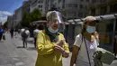 Orang-orang yang memakai masker berjalan di sepanjang jalan di Madrid, Kamis (24/6/2021). Hampir setahun setelah masker menjadi wajib di dalam dan luar ruangan, orang-orang mulai Sabtu tidak akan lagi diharuskan memakainya di luar selama mereka dapat menjaga jarak 1,5 meter (AP Photo/Manu Fernandez)