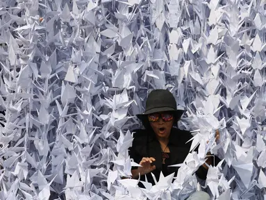 Warga berada di tengah-tengah burung origami di halaman depan Balai Kota, Jakarta, Sabtu (27/5). Seribu Origami Burung Perdamaian imi merupakan aksi atau gerakan spontanitas atas dasar kecintaan kepada NKRI. (Liputan6.com/Angga Yuniar)