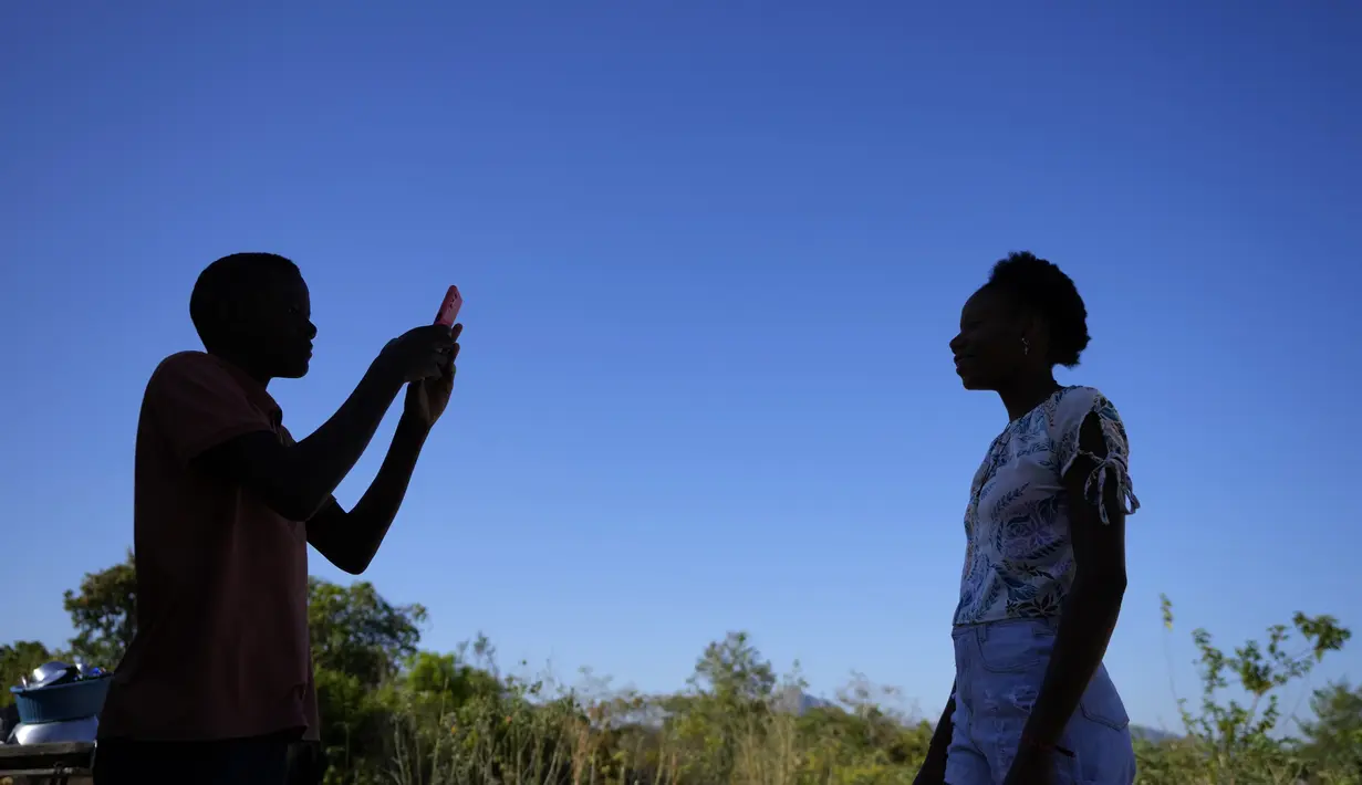 Seorang penduduk mengambil foto saudaranya dari ponselnya di Kalunga quilombo, di daerah pedesaan Cavalcante di negara bagian Goias, Brasil, Senin (15/8/2022). Nenek moyang penduduk desa Kalunga quilombo menetap di sana sebagai budak yang melarikan diri lebih dari 200 tahun yang lalu. (AP Photo/Eraldo Peres)