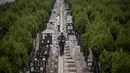 Seorang pria berjalan diantara batu nisan saat festival Qingming di sebuah pemakaman di Shanghai (6/6). Untuk orang Tionghoa, perayaan ini dilakukan untuk mengingat dan menghormati nenek moyang. (AFP/Johannes Eisele)