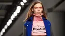 Model mengenakan crop top label Fyodor Golan edisi Fall/Winter 2017 dengan logo Post-it selama London Fashion Week di London, 17 Februari 2017. Label Inggris itu menunjukkan busana yang unik dan inspirasinya datang dari meja kerja. (NIKLAS HALLE'N/AFP)