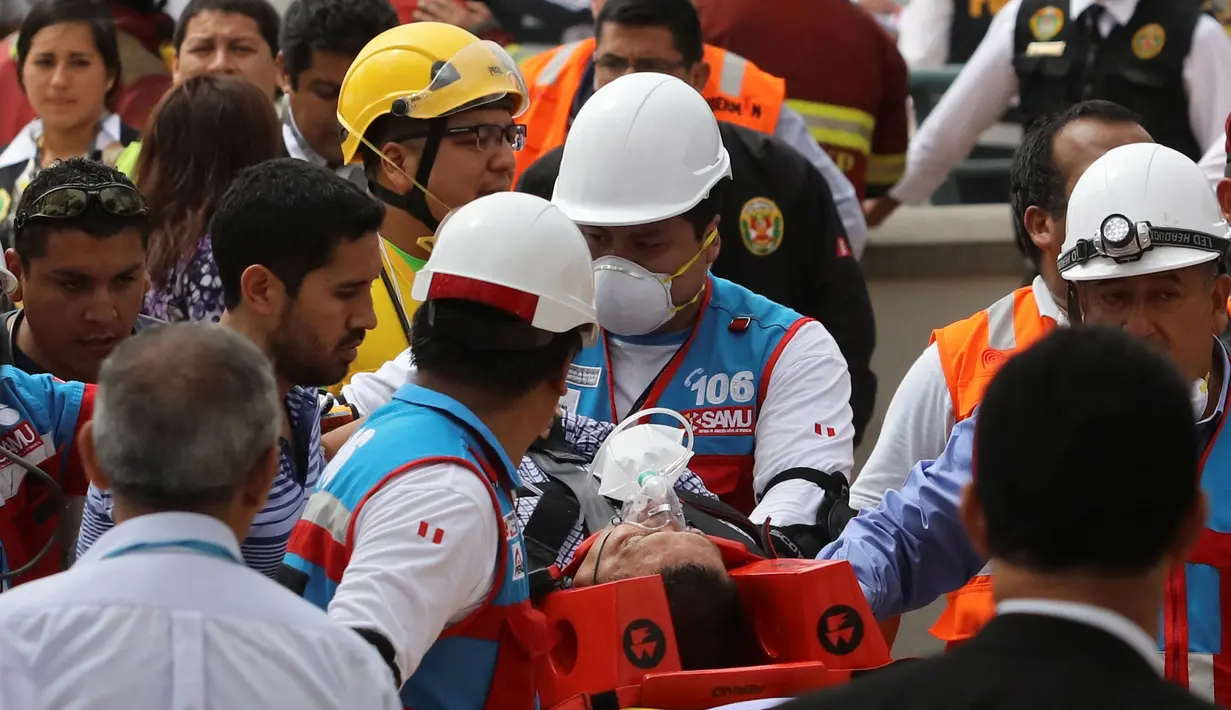 Petugas medis mengevakuasi salah satu korban kebakaran yang melanda Mal Larcomar di pusat Ibu Kota Peru, Lima, Rabu (16/11). Lokasi kebakaran berada di dekat hotel yang akan digunakan para delegasi KTT APEC tinggal. (REUTERS/Guadalupe Pardo)