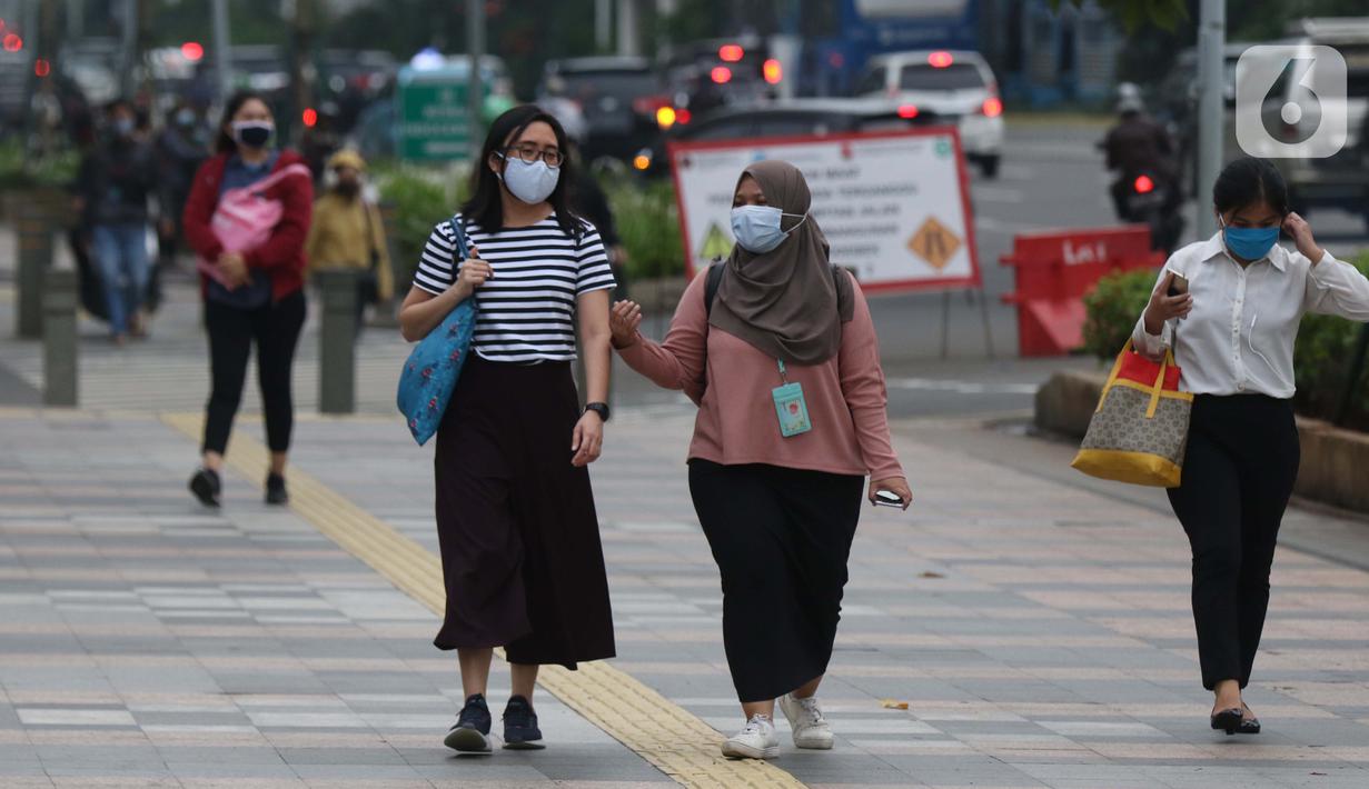 Warga mengenakan masker berjalan di pedestrian Jalan Jenderal Sudirman, Jakarta, Kamis (5/11/2020). BPS mencatat ekonomi Indonesia pada kuartal III-2020 minus 3,49 persen, Indonesia dipastikan resesi karena pertumbuhan ekonomi dua kali mengalami minus. (Liputan6.com/Helmi Fithriansyah)