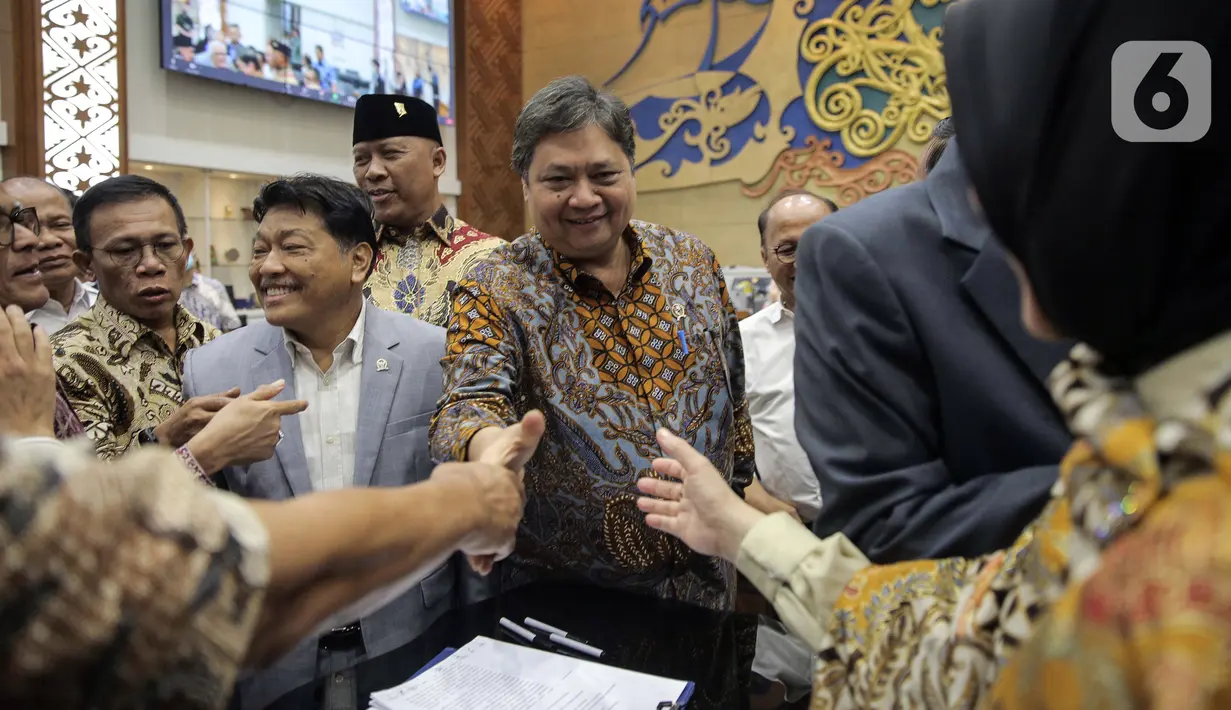 Menko Perekonomian Airlangga Hartarto menyalami sejumlah orang usai menandatangani draft Peraturan Pemerintah Pengganti Undang-Undang (Perppu) Cipta Kerja di Kompleks Parlemen, Senayan, Jakarta, Rabu (15/2/2023). Baleg DPR menyetujui untuk membawa Perppu Cipta Keria ke Paripurna dan disahkan menjadi Undang-Undang (UU). (Liputan6.com/Faizal Fanani)