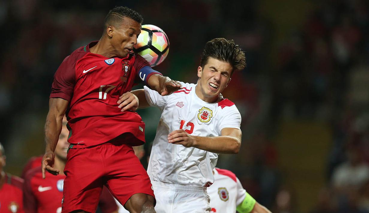 Penyerang Portugal, Nani, duel udara dengan pemain Gibraltar, Mascarenhas Olivero. Sejak menit awal Portugal langsung bermain menyerang menekan pertahanan Gibraltar. (EPA/Hugo Delgado)