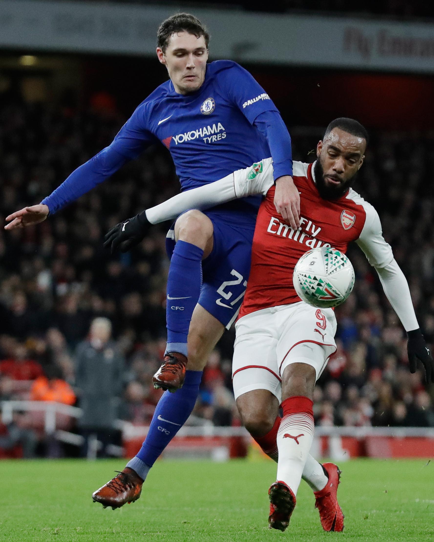 Pemain Arsenal, Alexandre Lacazette berebut bola dengan pemain Chelsea, Andreas Christensen pada laga leg kedua babak semifinal Piala Liga di Stadion Emirates, Kamis (25/1). Tiket final Piala Liga jatuh ke tangan Arsenal usai menang 2-1. (AP/Matt Dunham)