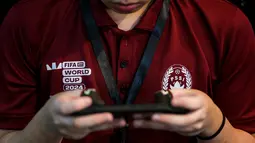 Seorang peserta kategoir mobile berkompetisi dalam seleksi nasional atau Indonesia National Qualifier FIFAe World Cup 2024 yang berlangsung di Point Arena, Jakarta Selatan, Sabtu (02/11/2024). (Bola.com/Bagaskara Lazuardi)