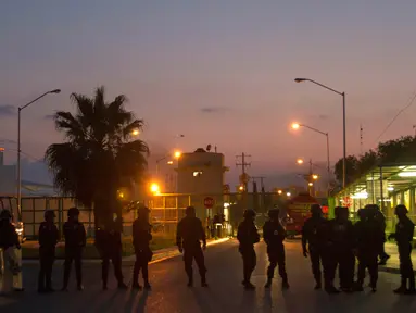  Petugas kepolisian anti huru-hara berjaga-jaga setelah terjadinya bentrokan di penjara Cadereyta di Monterrey, Meksiko, (27/3). Dikabarkan akibat kerusuhan ini setidaknya 45 orang terluka antaranya penjaga dan tahanan. (AFP Photo / Julio Cesar Aguilar)