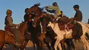 Penunggang kuda Afghanistan bersaing memperebutkan bangkai hewan dalam pertandingan Buzkashi di Herat, Afghanistan (4/2/2022). Buzkashi merupakan tradisi yang dilakukan oleh warga Afghanistan yang setiap pesertanya harus menunggang kuda. (AFP/Wakil Kohsar)