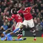 Gelandang Manchester United, Paul Pogba berusaha melewati bek Atletico Madrid, Renan Lodi pada pertandingan leg kedua babak 16 besar Liga Champions di Old Trafford, Inggris, Rabu (16/3/2022). Atletico Madrid menang atas MU 1-0. (AP Photo/Dave Thompson)