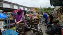 Warga membersihkan barang-barang setelah banjir surut di Mentakab, negara bagian Pahang, Malaysia (11/1/2020). Hujan deras yang terus melanda beberapa bagian jalan raya Pantai Timur di Pahang membuat daerah tersebut terendam banjir parah. (AFP/Mohd Rasfan)
