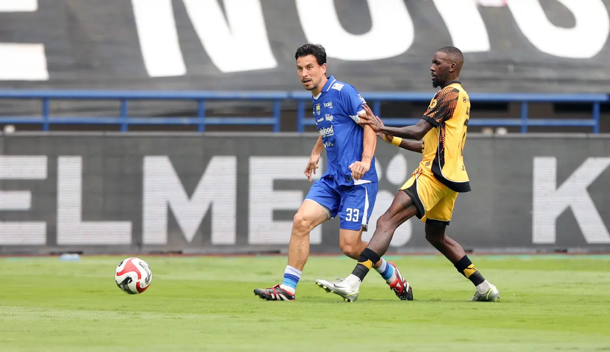 Pemain Persib Bandung, Thom Haye (kiri) berusaha melepaskan umpan dibayangi pemain Persija Jakarta, Allano De Souza Lima dalam laga lanjutan BRI Super League 2025/2026 di Stadion Gelora Bandung Lautan Api, Bandung, Minggu (11/01/2026). (Bola.com/Abdul Aziz)