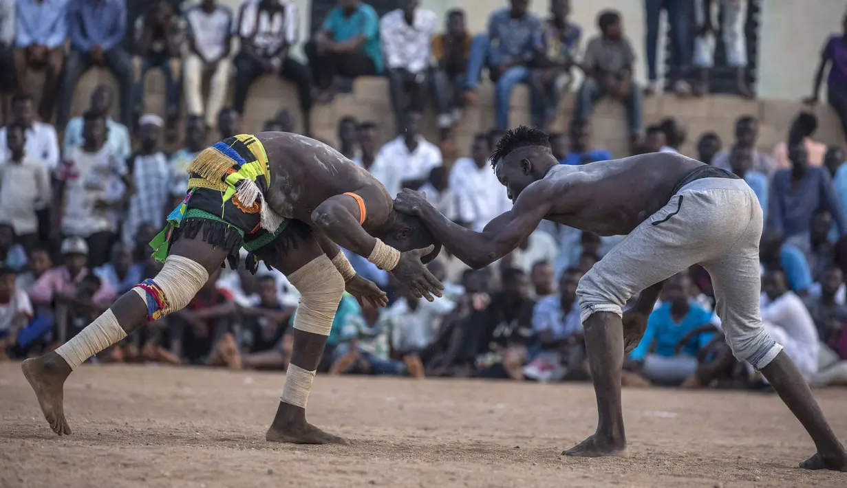 Pegulat tim dari daerah Haj Youssef dan Omdurman bersaing dalam kompetisi gulat tradisional Nuba di Ibu Kota Khartoum, Sudan, 30 Juli 2021. (Abdulmonam EASSA/AFP)