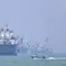 Sebuah perahu motor kecil melewati kapal-kapal yang berlabuh di Selat Hormuz di lepas pantai Bandar Abbas, Iran, Kamis, 11 Juni 2026. (Amirhosein Khorgooi/ISNA via AP)