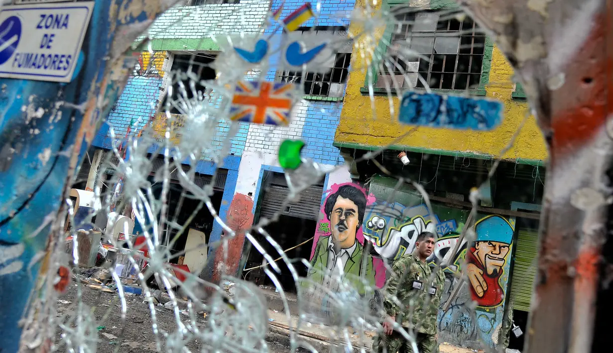 Polisi berjaga di kampung narkoba dan prostitusi The Bronx di Bogota, Kolombia (1/6). Sedikitnya 200 perempuan diselamatkan setelah ditahan dan dieksploitasi seksual oleh para germo dan bandar narkoba di wilayah tersebut. (AFP PHOTO/Guillermo LEGARIA)