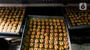 Kue setelah dimasukan dalam oven di industri pembuatan kue kering Pusaka Kwitang, Jakarta, Kamis (30/4/2020). Kue kering yang dijual seharga Rp480 ribu per kaleng itu pada bulan Ramadan tahun ini mengalami penurunan produksi hingga 500 kaleng akibat pandemi COVID-19. (Liputan6.com/Johan Tallo)