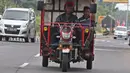 Pemudik bersama keluarganya menggunakan motor bak roda tiga saat perjalanan mudik melintasi Jalur Pantura kawasan Pemalang, Jawa Tengah, Senin (3/6/2019). Keluarga ini sudah sejak tiga tahun lalu menggunakan motor bak roda tiga untuk mudik. (Liputan6.com/Herman Zakharia)