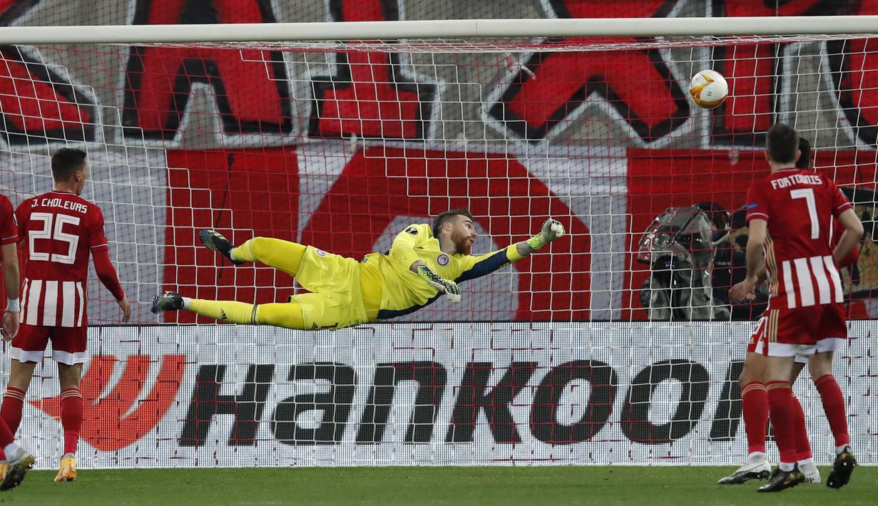Kiper Olympiakos, Jose Sa kebobolan gol kedua lewat tendangan yang dilepaskan bek Arsenal, Gabriel dalam laga leg pertama babak 16 besar Liga Europa 2020/2021 di Georgios Karaiskakis Stadium, Kamis (11/3/2021). Olympiakos kalah 1-3 dari Arsenal. (AP/Thanassis Stavrakis)