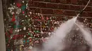 Petugas menyemprotkan air ke dinding yang tertutup permen karet di Pike Place Market, Seattle, Rabu (11/11). Diperkirakan sekitar satu juta permen karet melekat pada tembok yang dikenal "tembok permen karet" itu sejak tahun 1991. (AFP PHOTO/Jason Redmond)