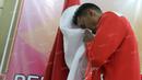 Anggota Tim Thomas Indonesia, Tommy Sugiarto, mencium bendera merah putih saat acara pelepasan tim Thomas-Uber Indonesia di Pelatnas Bulutangkis PBSI, Cipayung, Jakarta, (9/5/2016). (Bola.com/Arief Bagus)