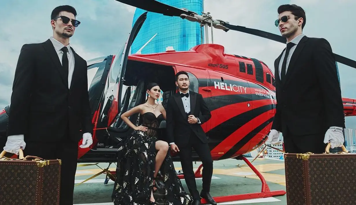 Dengan berbalutkan outfit glamor dan klasik dinamis, Syahnaz dan Jeje tampak seperti bangsawan. Berpose di helipad Shangri-La, Jakarta. Helicopter pun juga khusus disewa di konsep prewedding. (Instagram/riomotret)