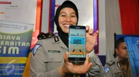 Petugas Kakorlantas Polri memperlihatkan aplikasi SIM Online saat launching di Jakarta, Jumat (16/12). Dalam rangka meminimalisir pungli, Korlantas merilis 3 aplikasi mulai dari SIM online, e-Tilang, hingga e-Samsat. (Liputan6.com/Angga Yuniar)